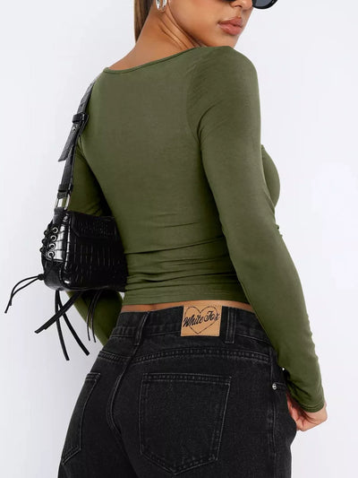 Woman wearing a trendy fitted tee in olive green paired with high-waisted black jeans