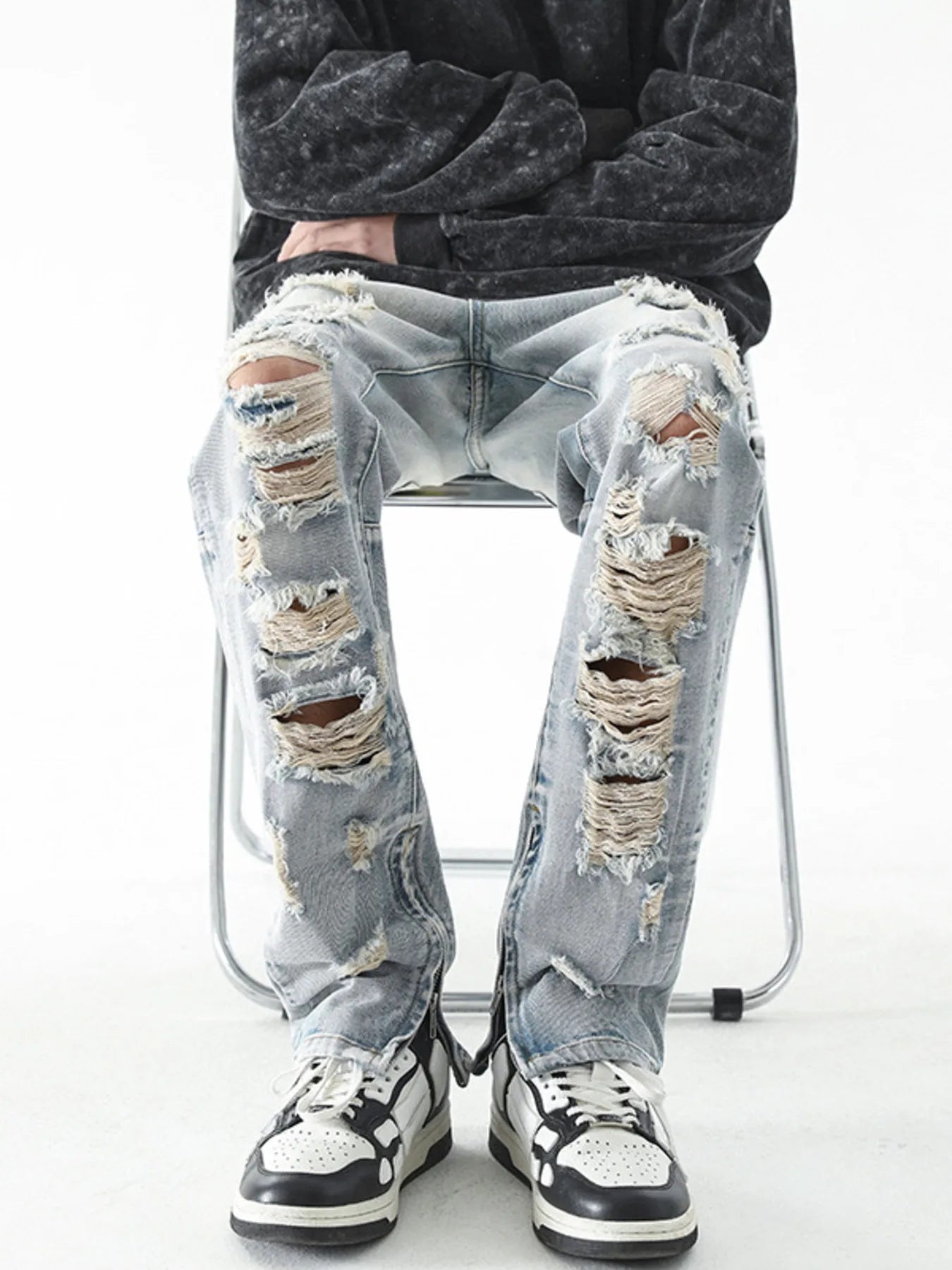 Trendsi model wearing men's distressed straight jeans light wash heavily ripped with frayed knees and sneakers