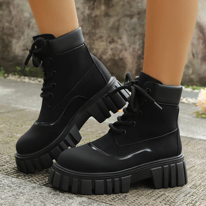 Black chunky lace up Platform Combat Boots on model feet with thick ridged sole for edgy street style