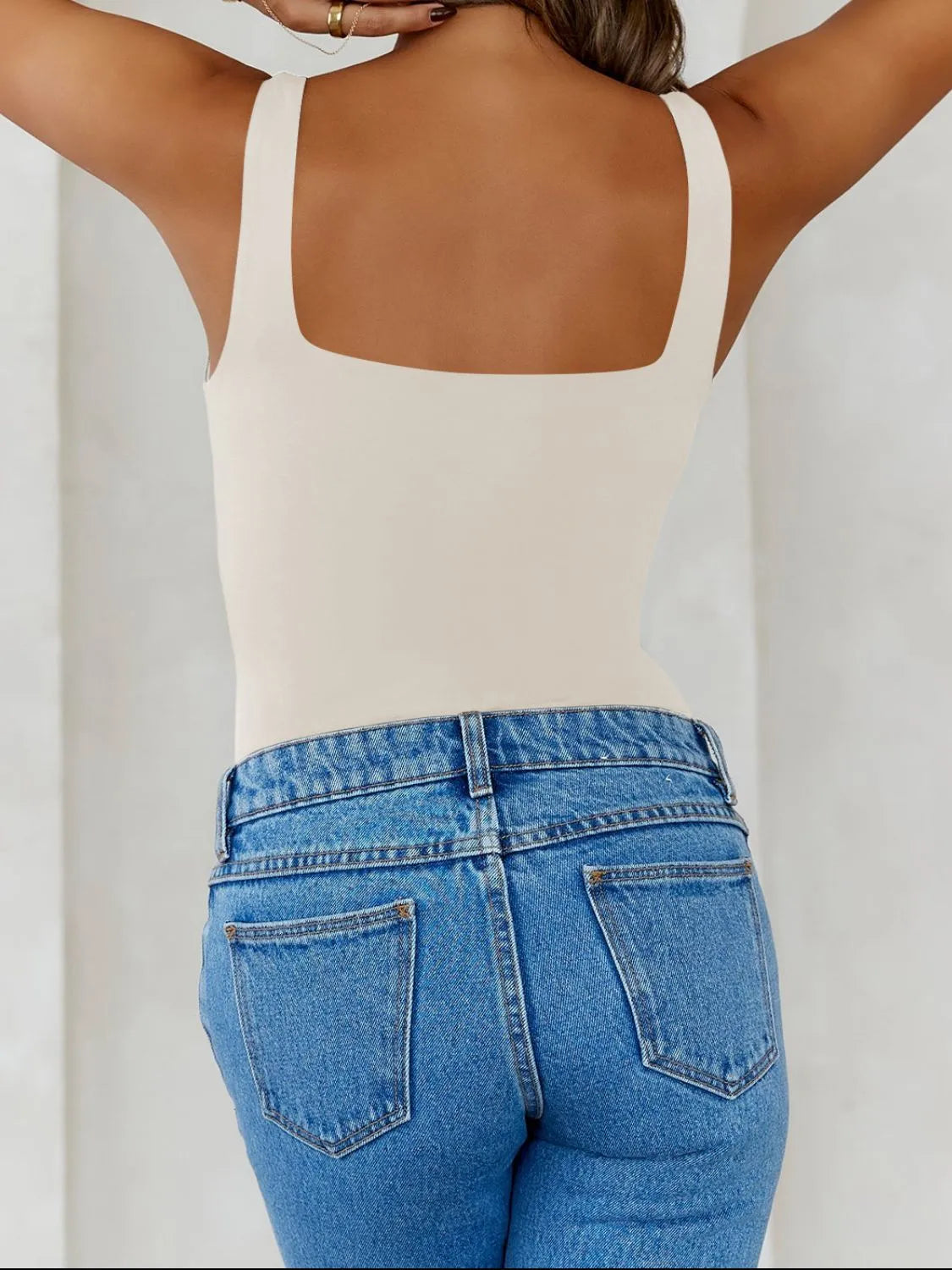 Trendsi V-Neck Tank Top in beige displayed on a model with light blue high-waisted jeans