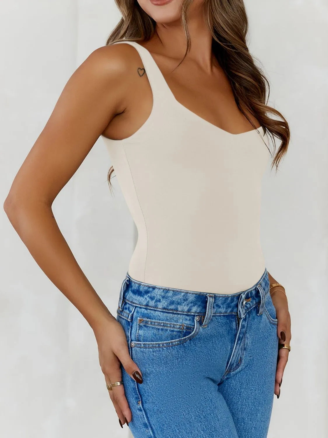 Trendsi V-Neck Tank Top in Beige paired with High-Waisted Blue Denim Jeans for a Stylish Look