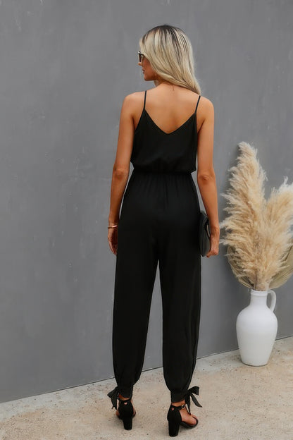 CCWHOLESALECLOTHING black v neck spaghetti strap jumpsuit back view on blonde model with ankle ties