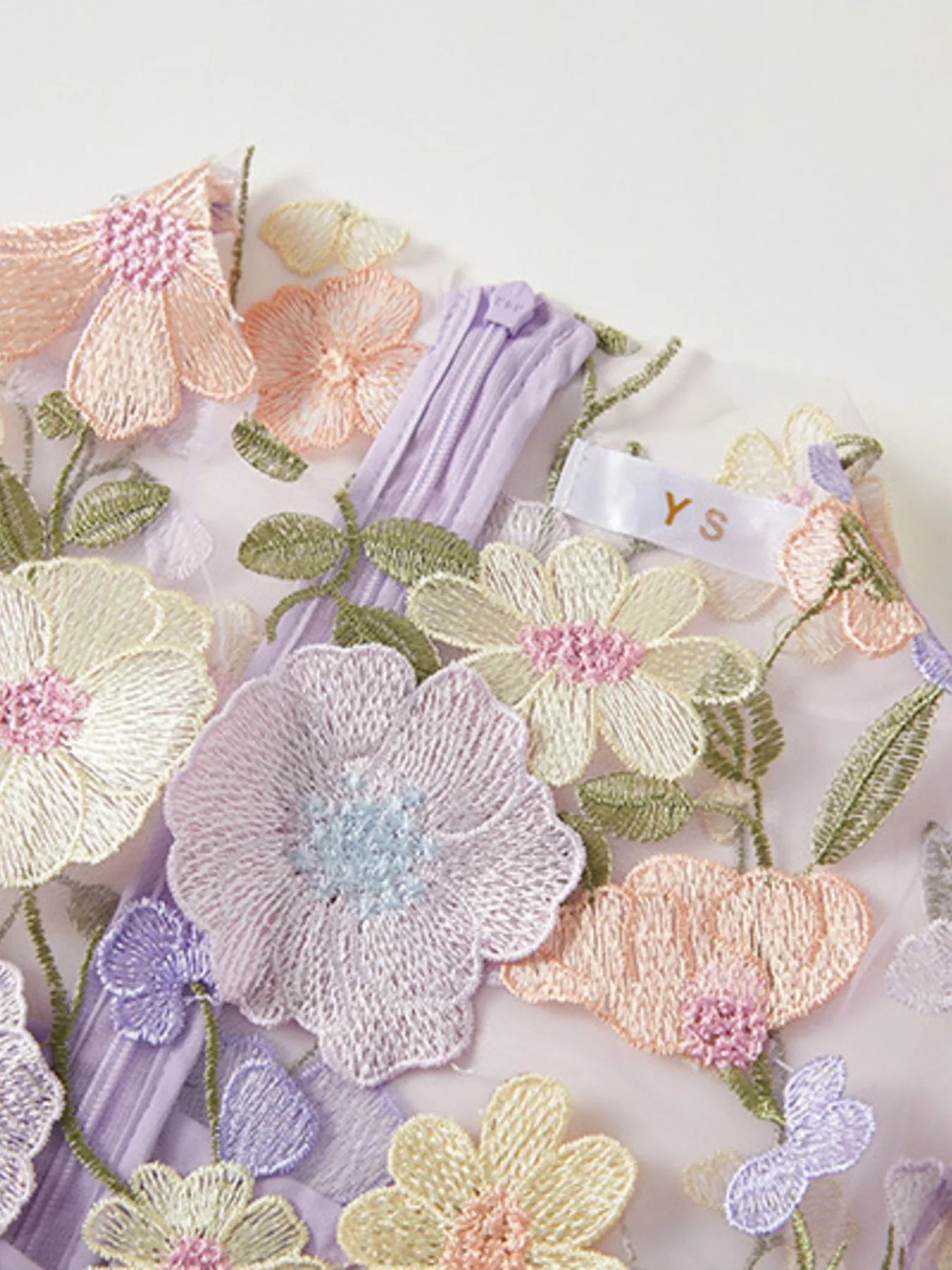 Lined Evening Gown with pastel floral embroidery on sheer fabric and lavender lining close up